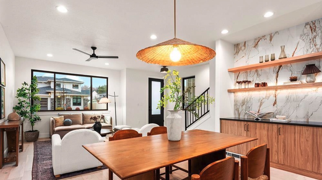 Open dining and living space with finished flooring and feature backsplash