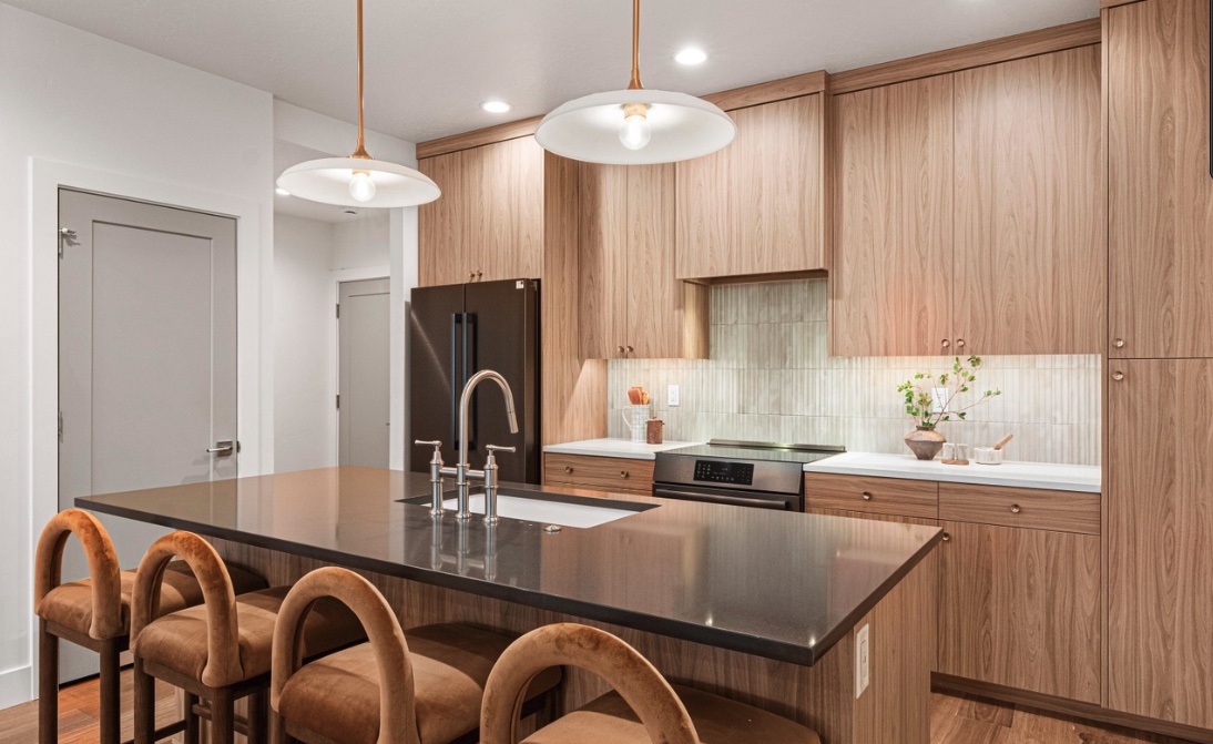 Warm modern kitchen with wood cabinetry, tiled backsplash, and large island