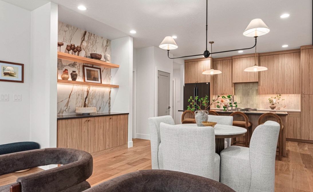 Open dining and kitchen space with warm wood flooring and two feature backsplashes